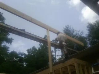 Carpenter setting a ridge beam over a new addition frame — Ice Dam Removal by Roofing Brothers in Teaneck
