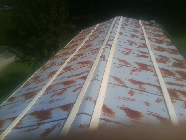 Rusted metal roof panels with new wood purlins before replacement — Storm Damage Roof Repair in Teaneck by Roofing Brothers