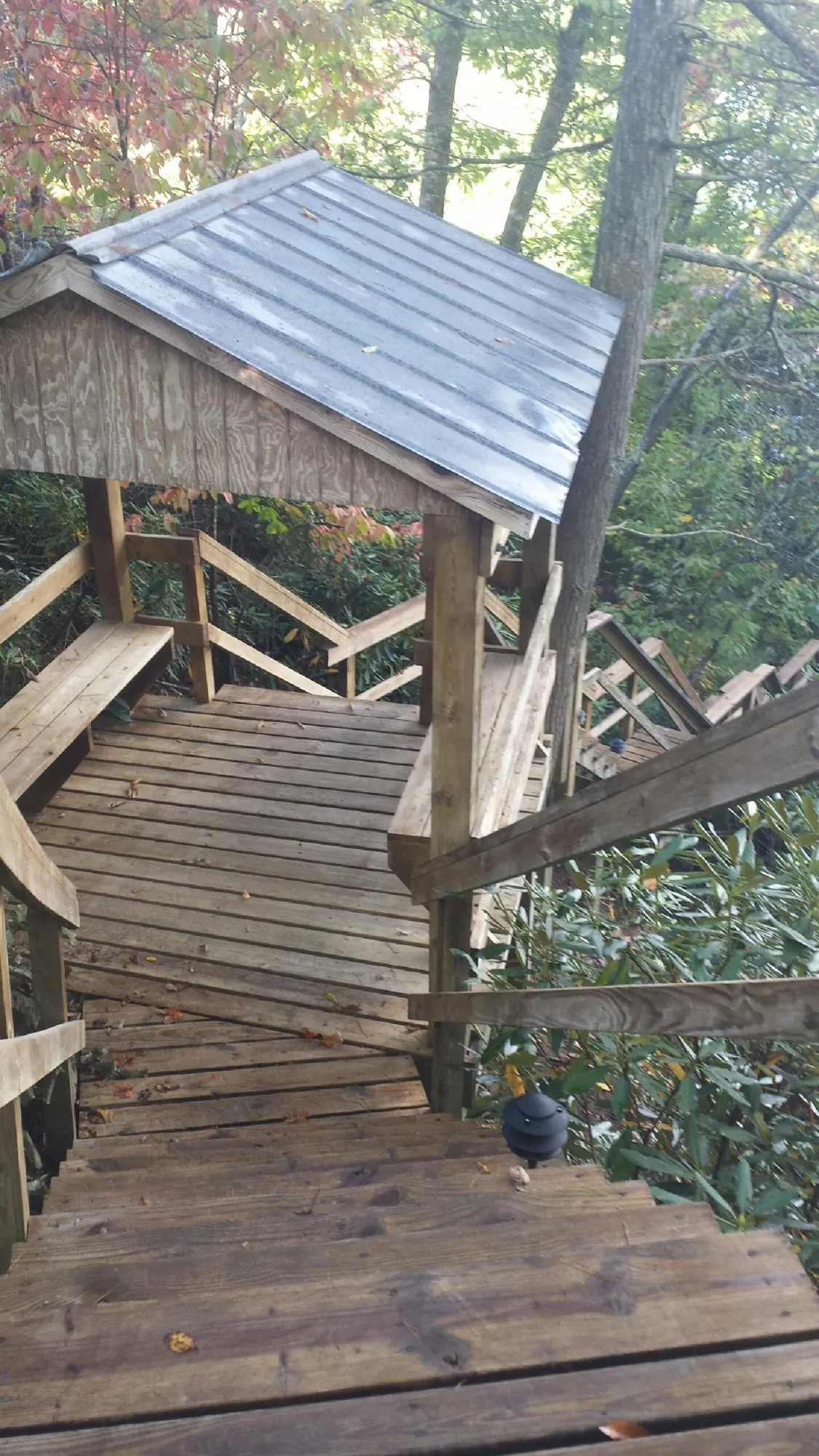 Metal roofed shelter over wooden steps on a wooded walkway — Skylight Repair & Installation work by our crew in Teaneck