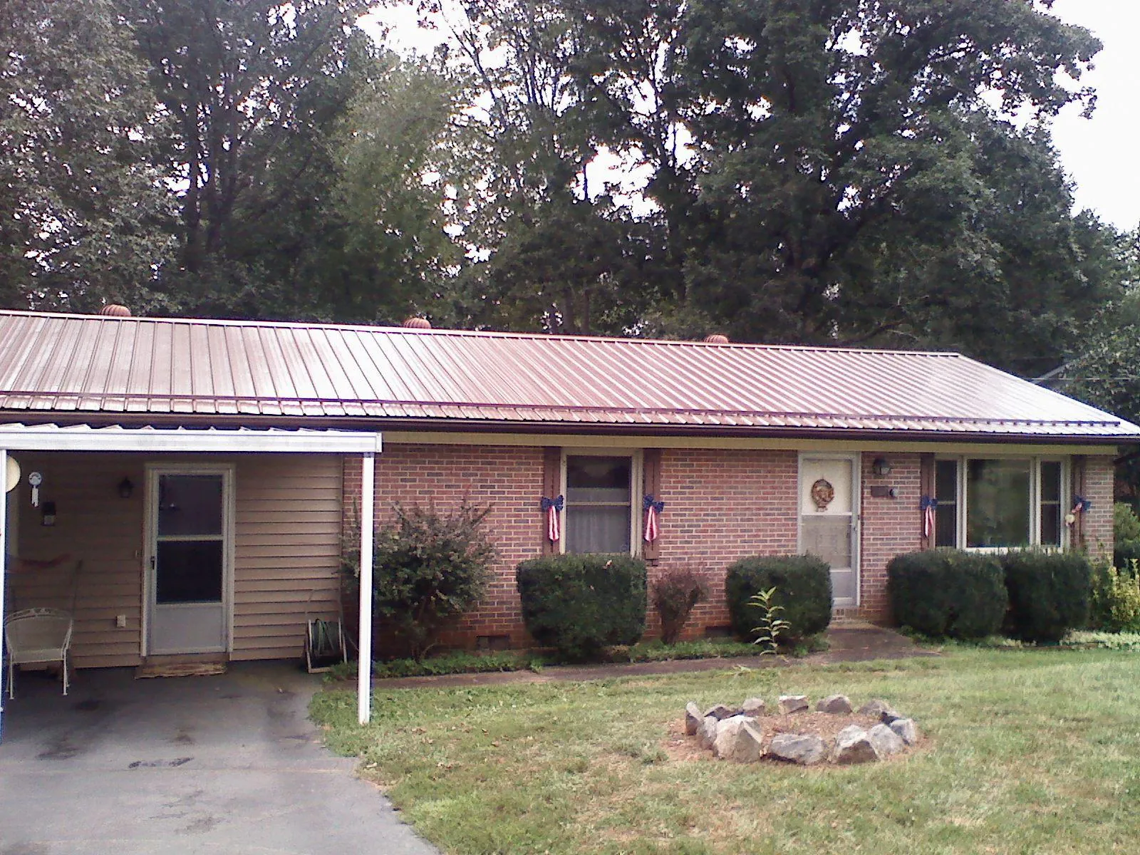 Bronze metal roof and carport on a brick ranch home — Roof Repair work by our crew in Teaneck